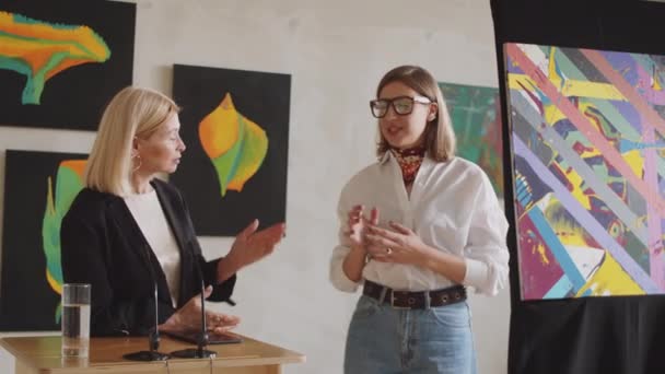 Ung Kvinnlig Konstnär Står Bredvid Auktionsförrättare Och Ger Presentation Sin — Stockvideo