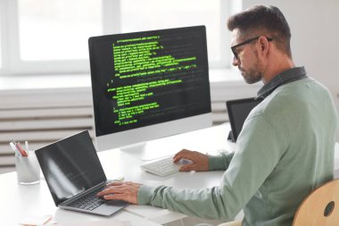 Masaüstü bilgisayarı üzerinde çalışan programcı