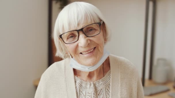 Brustporträtaufnahme Einer Fröhlichen Seniorin Mit Schützender Gesichtsmaske Unter Dem Kinn — Stockvideo