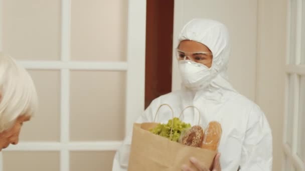 Cheerful Female Volunteer Protective Suit Mask Glasses Bringing Bag Groceries — Video Stock