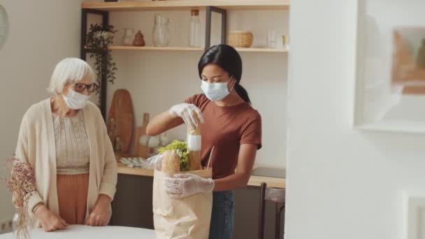 Young Female Caregiver Disposable Mask Gloves Unloading Groceries Bag Kitchen — Video Stock