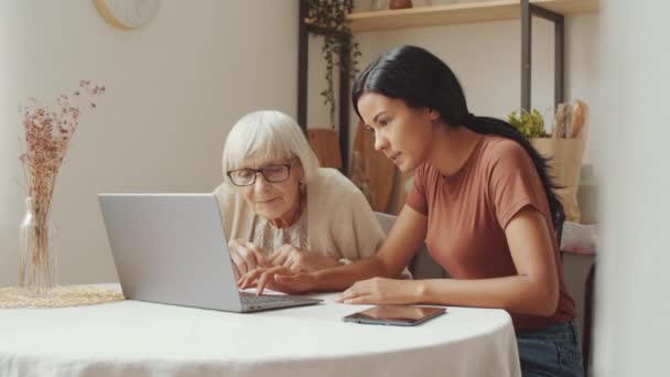 Young Asian Female Volunteer Sitting Table Senior Caucasian Woman Explaining — Video Stock