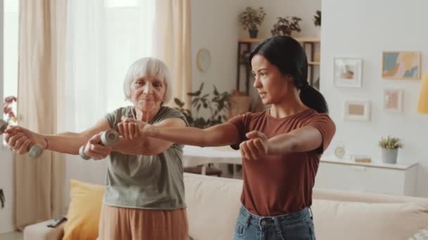 Asian Female Fitness Instructor Teaching Senior Woman How Exercise Dumbbells — Vídeo de Stock