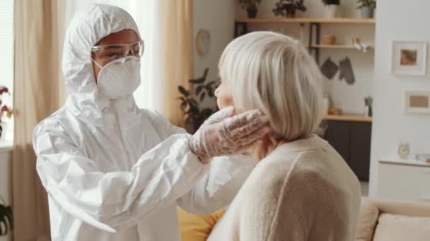 Ärztin Schutzanzug Untersucht Lymphknoten Hals Und Rachen Der Seniorin Während — Stockvideo