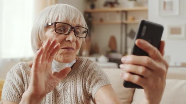 Cheerful Elderly Woman Medical Mask Her Chin Sitting Sofa Home — Video Stock