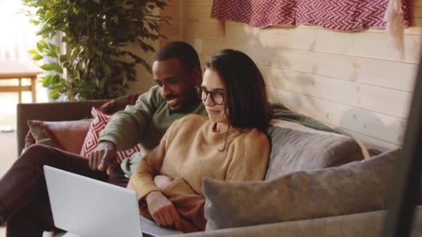 Jeune Couple Multiethnique Assis Ensemble Sur Canapé Dans Une Maison — Video