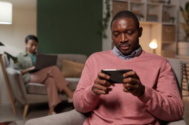 Telefonda oynayan adam.