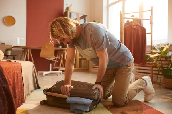 Hombre cerrando su maleta — Foto de Stock