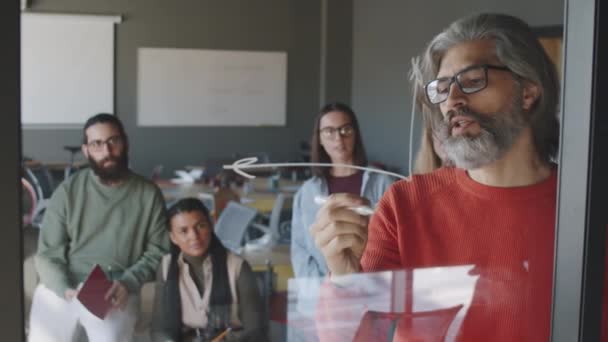 Senior Grey Haired Male Manager Drawing Graph Glass Wall Marker — Stock Video