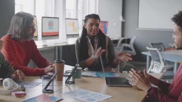 젊은아 미국인 사업가가 사무실에서 회의에서 동료들에게 무언가를 설명하고 있습니다 — 비디오