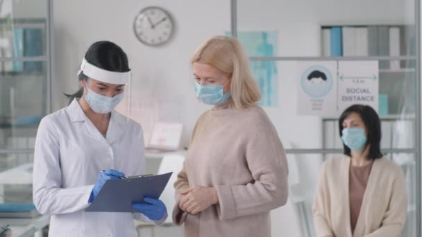 Mujer Con Mascarilla Protectora Hablando Con Doctora Asiática Mientras Tiene — Vídeos de Stock