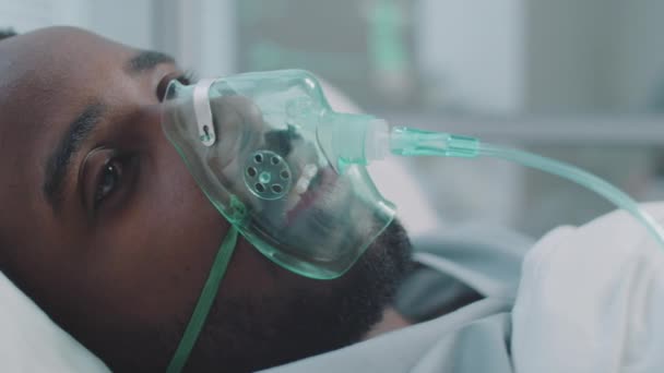 Primer Plano Hombre Afroamericano Enfermo Acostado Con Máscara Ventilador Mirando — Vídeos de Stock