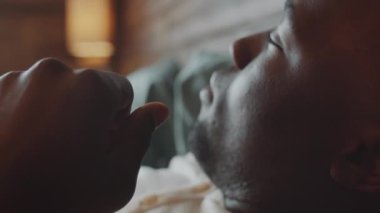 Genç Afro-Amerikalı adamın uyandığı ve evde gözlerini ovuşturduğu yakın çekim.