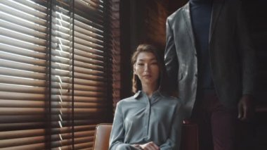 Genç ve güzel Asyalı kadın ve Afro-Amerikalı kocasının kamera önünde kamera karşısında ana ofiste perdelerle poz verişini çek.