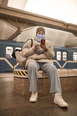 Metroda telefon kullanan bir kadın.