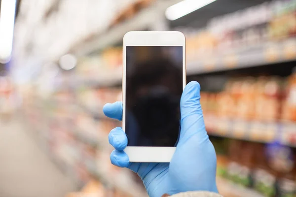 Usando telefone no supermercado — Fotografia de Stock