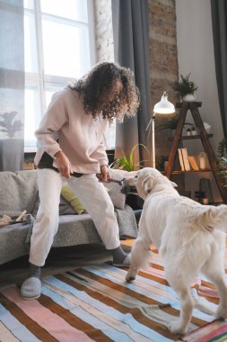 Kadın evcil hayvanıyla oynuyor.