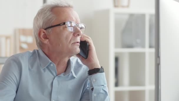 Senior Businessman Sedí Stolem Kanceláři Mluví Smartphone Drží Pero Dělá — Stock video