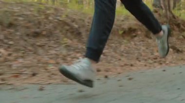 Spor giyim kuşağında sabah parkta koşan bir adamın zemin katındaki izleme görüntüsü.