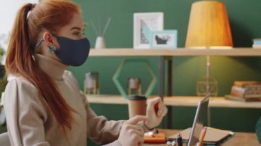 Korumacı yüz maskesi takmış genç beyaz kadının KVID-19 salgını sırasında görevde çalışırken melez bir erkek arkadaşla iş tartışırken PAN fotoğrafı.