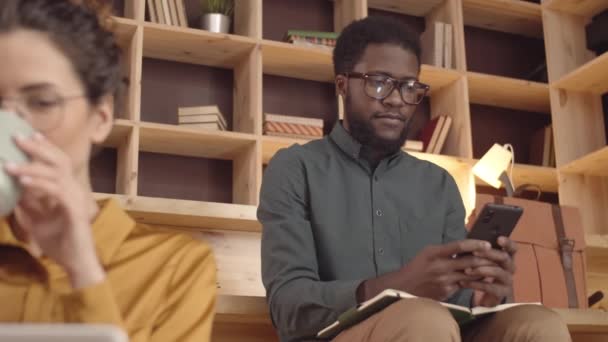 Knee Shot Focused Young African American Man Glasses Sitting Bench — Stock videók