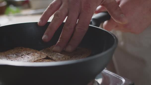 在厨房里做吐司的时候 一个无法辨认的男厨师把黑麦面包压在热锅里翻过来翻去 紧紧地握住他的手 — 图库视频影像