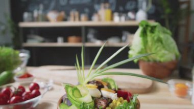 Sebze, salatalık ve mutfak masasında pırasa süslemelerle süslenmiş et kasesi.