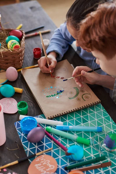 Barn som målar ägg vid bordet — Stockfoto