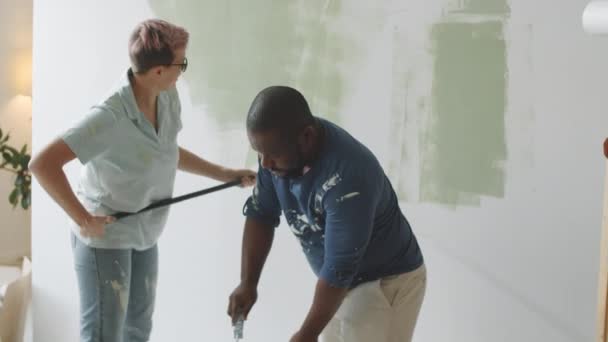 Multiethnic Family Couple Painting Walls Green Color Roller Covers While — Stock Video