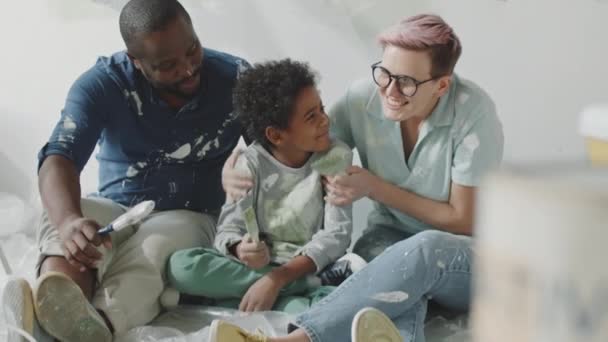 Tilt Shot Happy Multiethnic Family Sitting Together Floor Holding Paintbrushes — Stock Video