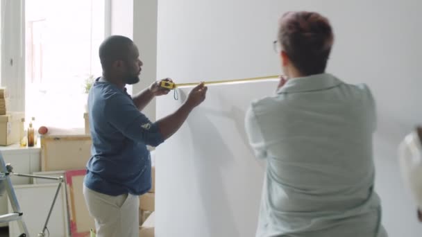 Afroamerikanischer Mann Und Seine Kaukasische Frau Messen Wand Mit Klebeband — Stockvideo