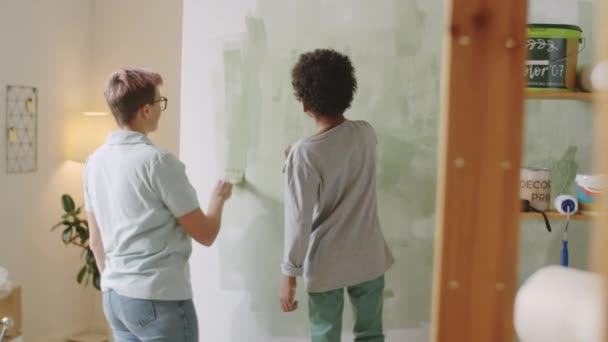 Back View Caucasian Mother Mixed Raced Little Son Painting Wall — Stock Video