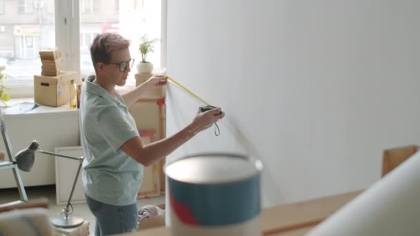 Mujer Joven Usando Cinta Métrica Mientras Mide Pared Habitación Bajo — Vídeo de stock