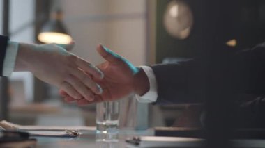 İki tanınmayan çoklu etnik iş adamının ofis masasında el sıkışmalarını yakından çek.