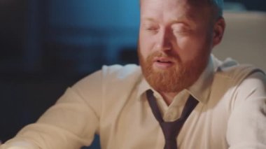 Depresyondaki iş adamının göğsünden, gözlerini ovuşturduğu ve akşamları işyerinde camdan viski içtiği bir fotoğraf.