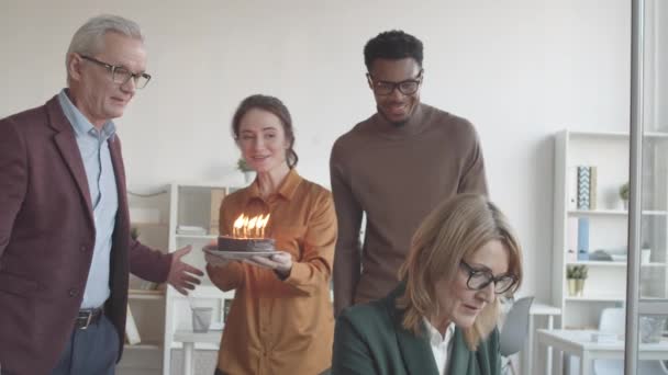 다국적 미디엄 동료가 사무실 책상에서 랩탑으로 일하는 케이크와 촛불을 태우고 — 비디오