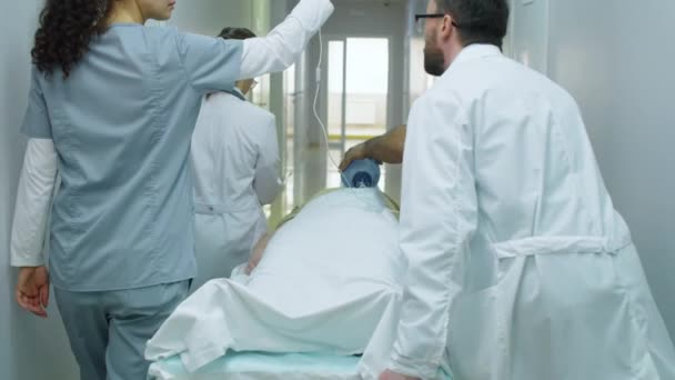 요원들이 복도를 구내에서 환자를 이송하는 마스크와 가방을 사용하는 — 비디오