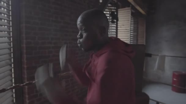 20来岁的非洲裔美国拳击手在格斗俱乐部参加帽子戏法 表演刺拳 高音高音高音和钩拳时的仰卧起坐镜头 — 图库视频影像