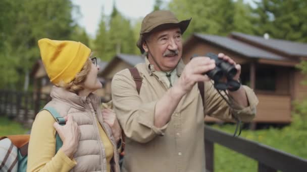 Glada Äldre Par Med Ryggsäckar Tittar Igenom Kikare Och Diskuterar — Stockvideo