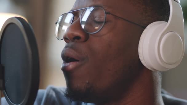 Primer Plano Del Joven Afroamericano Auriculares Inalámbricos Cantando Micrófono Mientras — Vídeo de stock
