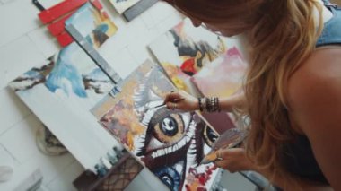 Yetenekli kadın ressamın, stüdyodaki yağlı boya resimleriyle çağdaş sanat tablosunu omuz üstü Hollanda açısı.