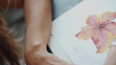 Profesyonel kadın sanatçının pastel boyalarla güzel çiçekler çizdiği yakın plan.