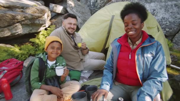 Glad Multietnisk Familj Sitter Campingplatsen Håller Tekoppar Tittar Kameran Och — Stockvideo