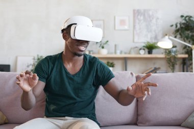 Adam sanal gerçeklik kulaklığıyla eğleniyor.