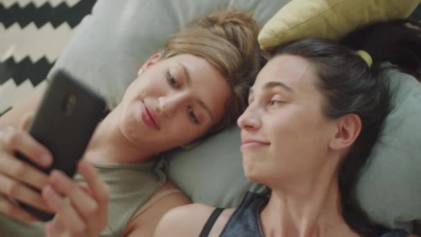 照片中 一对年轻夫妇躺在床上 用智能手机 聊着社交媒体 — 图库视频影像