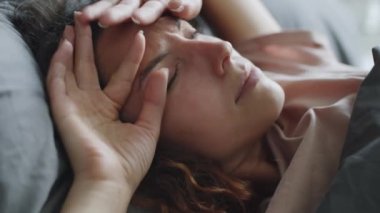 Kapalı el kamerasıyla, genç uykulu kadının sabah yatağında uyanırken çekilmiş görüntüleri.