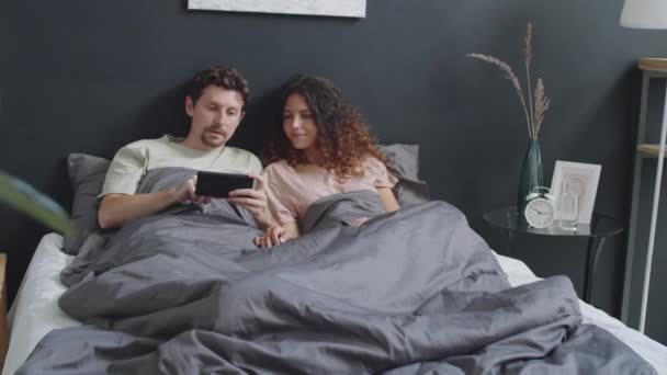 Caucasian Man Lying Bed Home Using Smartphone Discussing Something Screen — Stock Video
