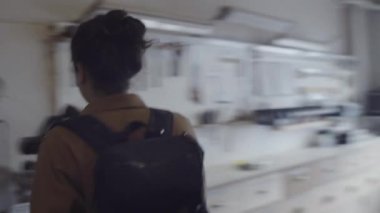 Beyaz tenli erkek marangozun atölyeye girerken, ışığı açarken, ceketini çıkarırken, duvar rafından el aletlerini çıkarırken ve mobilya üzerinde çalışırken göğsünden çekilen görüntüler.