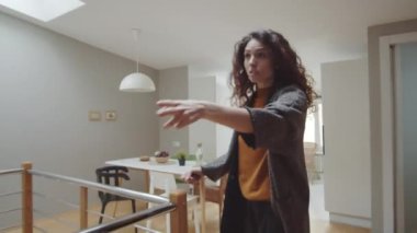 Beyaz güzel bir kadının, erkek arkadaşıyla tartışırken, merdivenlerden yukarı çıkarken, paltolarını çıkarırken, sözlü olarak birbirini taciz ederken ve alay ederken orta boy görüntüsü.