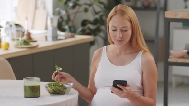 Güzel Hamile Kadın Mutfak Masasında Oturuyor Akıllı Telefon Kullanıyor Sebze — Stok video